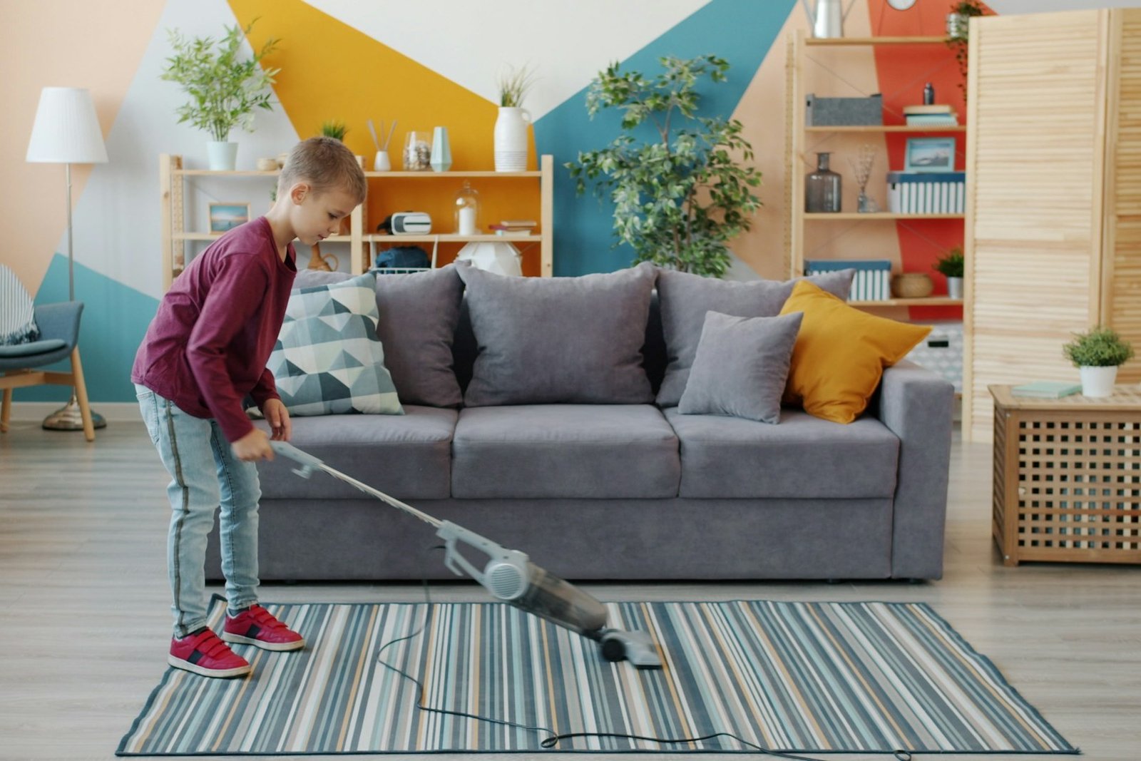 Eine Person saugt einen Teppich in einem Wohnzimmer mit einem Bodenstaubsauger