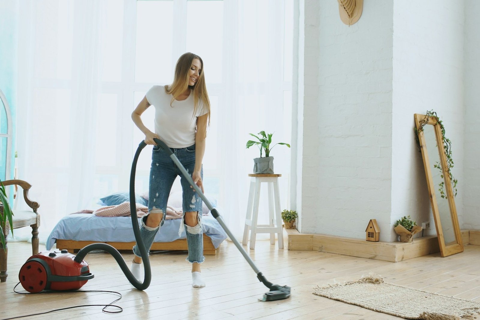 Ein flexibler Staubsaugerschlauch liegt neben einem Staubsauger auf dem Boden