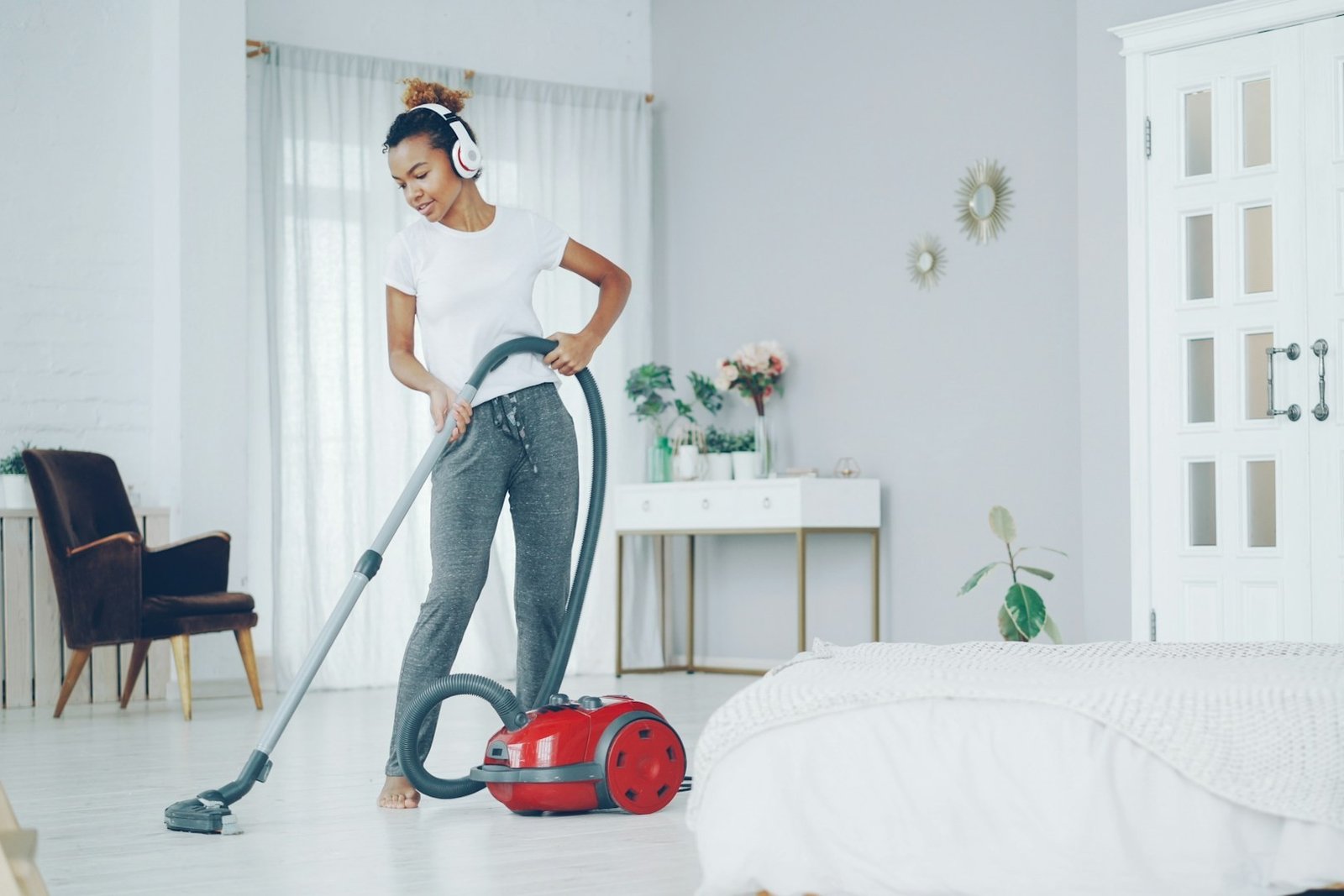 Ein abgenommener Staubsaugerschlauch liegt ausgestreckt auf dem Boden neben dem Gerät